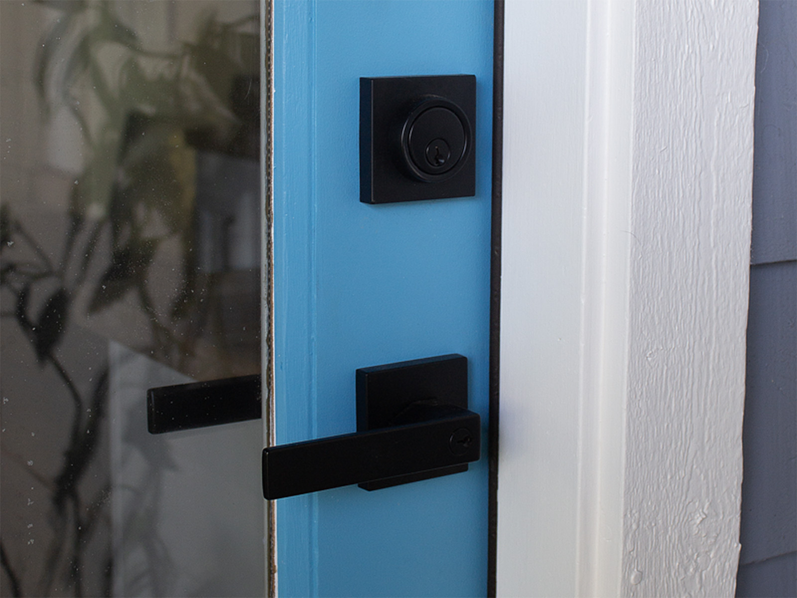 Complete entry door restoration including weather seal installation for improved energy efficiency, professional paint application, and sleek new hardware upgrade