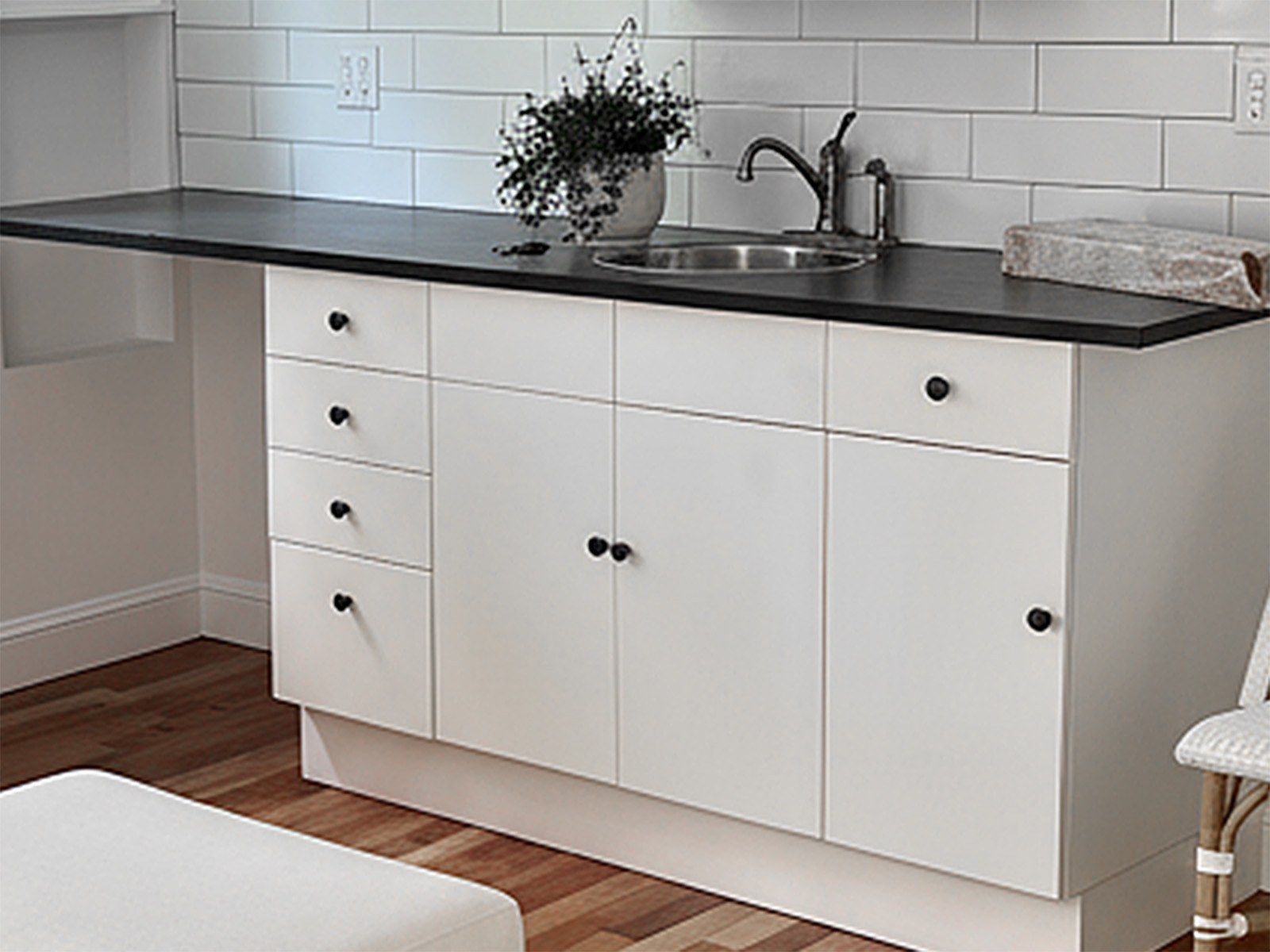 Custom wet bar installation including Ikea base and upper cabinetry with modern hardware, Ikea countertop, undermount sink with plumbing hookup, designer faucet, and professional subway tile backsplash with grouting